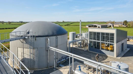 Installation de méthanisation agricole avec digesteur cylindrique métallique et bâtiment technique de cogénération dans un environnement rural français